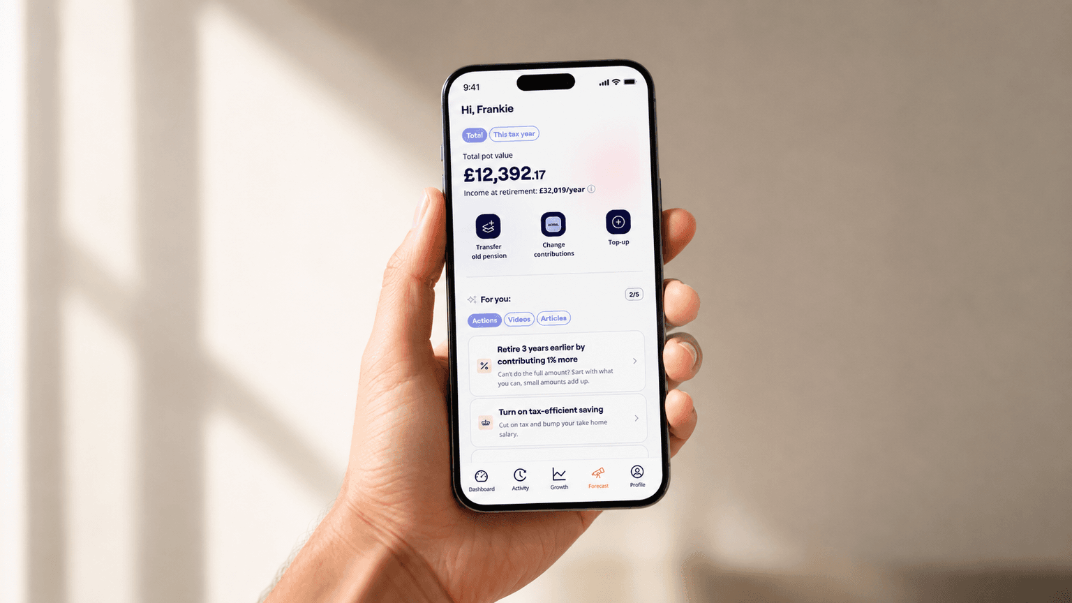 A hand holds a smartphone displaying a financial app with a pension value and suggested guidance on retirement planning features.